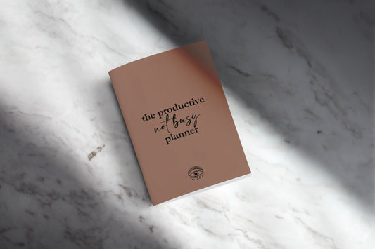 Cover of the productive not busy planner displayed on a marble counter