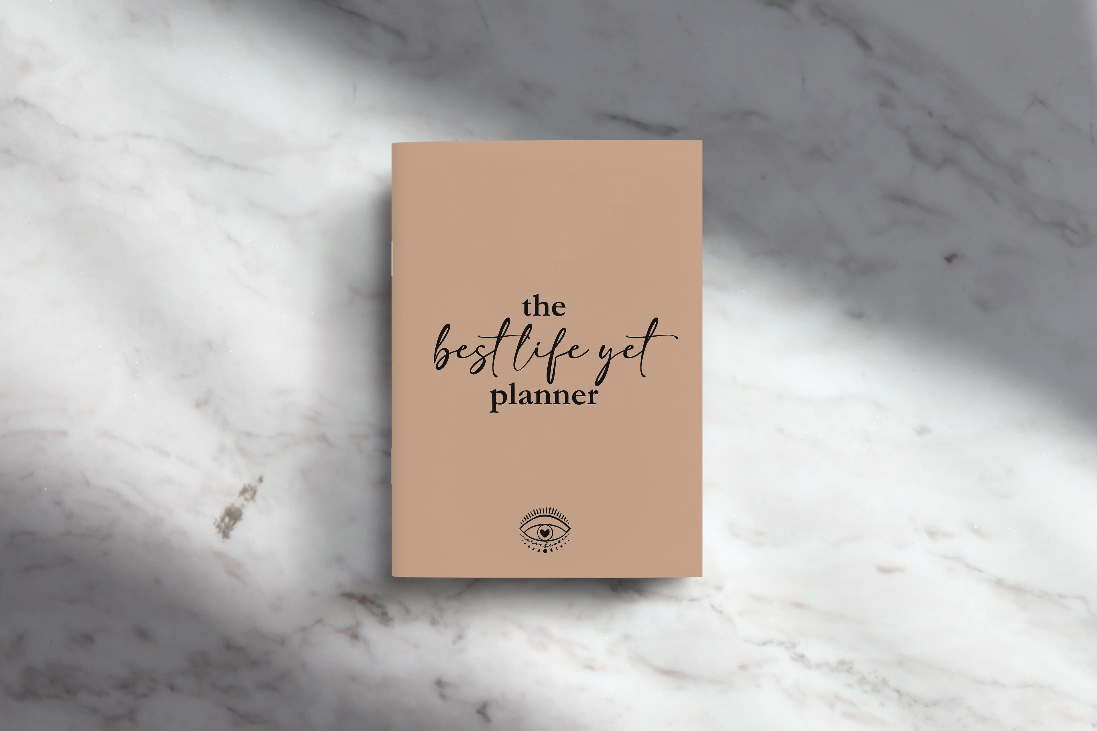 Our cover of our “The Best Life Yet Planner” displayed on a marble table